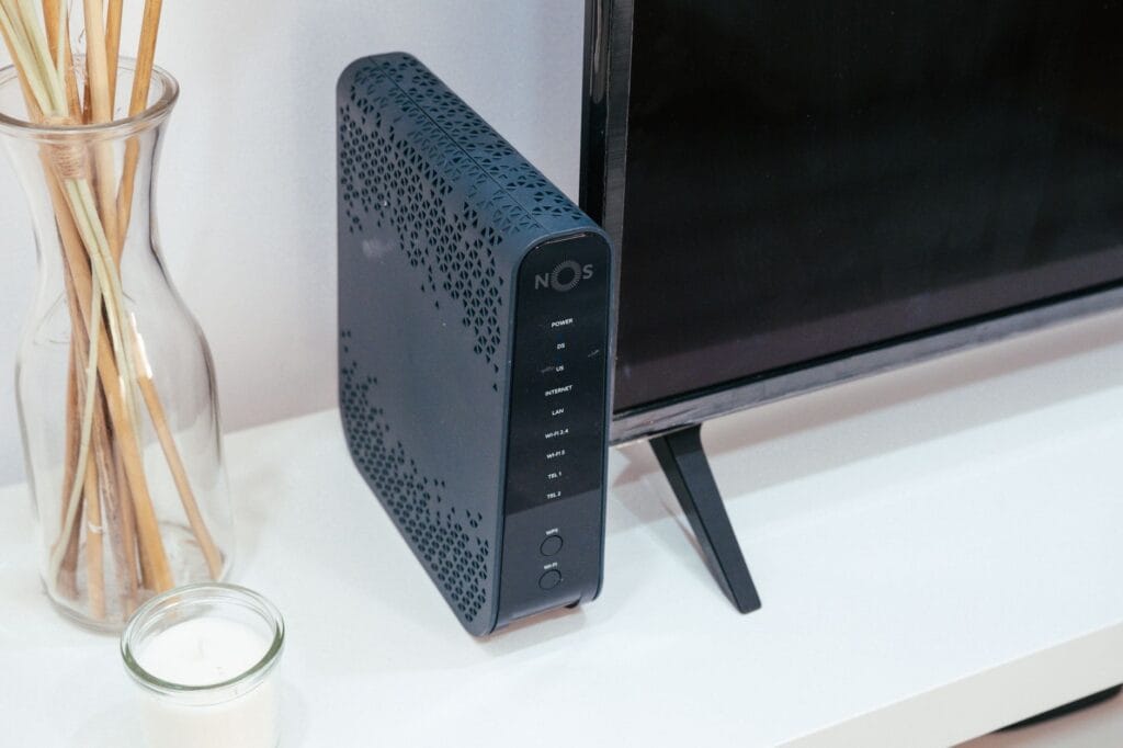 A home network router placed next to a TV on a media console, representing the network troubleshooting required when Chromecast casting fails.