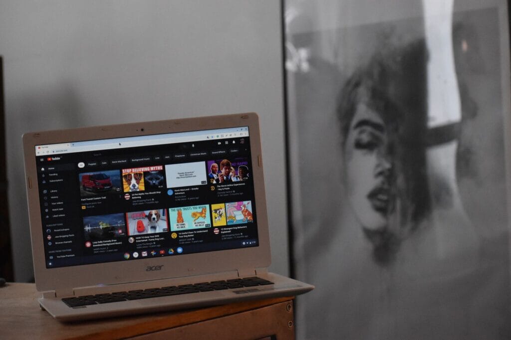 An Acer laptop displaying YouTube in a Chrome browser tab in a home setting, illustrating how to cast a Chrome tab to a TV.