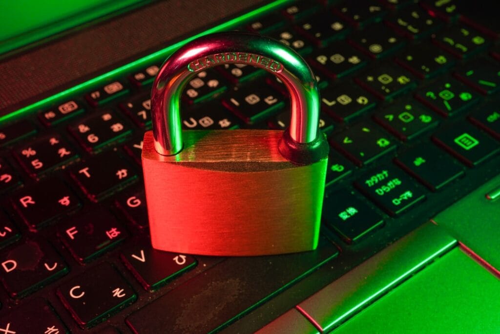 Video Player for Google Drive: Fix Playback Errors Fast A padlock resting on a laptop keyboard with red and green lighting, representing file sharing permission errors and access control