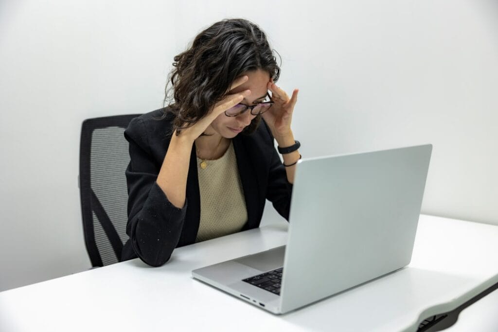 Person frustrated at laptop screen trying to troubleshoot a video URL that won't play