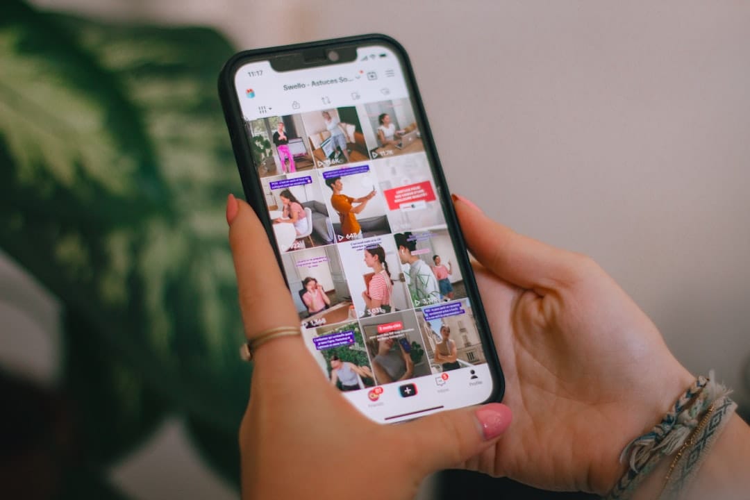8 Free iPhone Video Editing Apps: No Watermark Test Person holding a smartphone showing a TikTok-style social media grid feed, representing social content creation on mobile